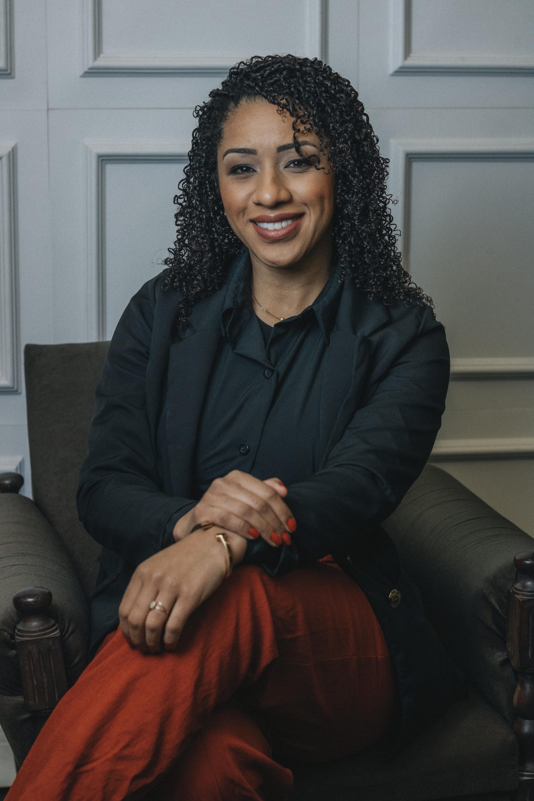 A confident woman sitting in an elegant chair, exuding professionalism and poise.